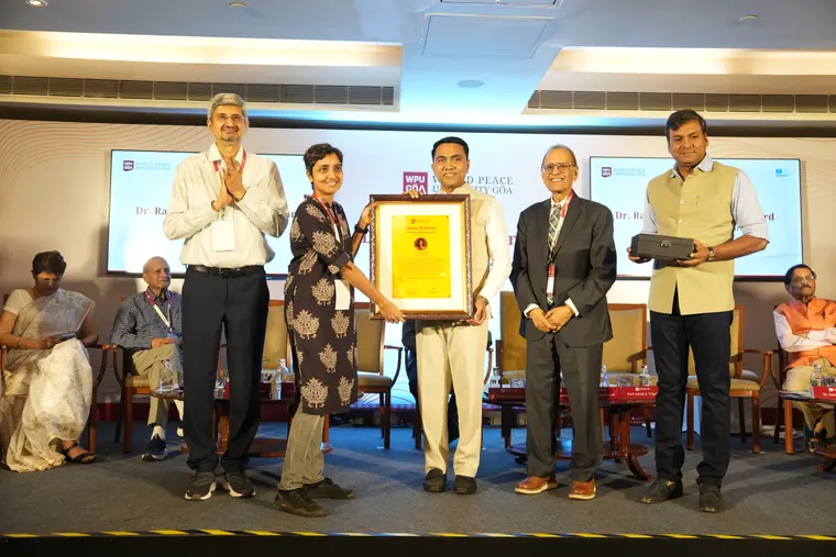 A researcher receives the Dr. Raghunath Mashelkar Award on stage at WPU GŌA
