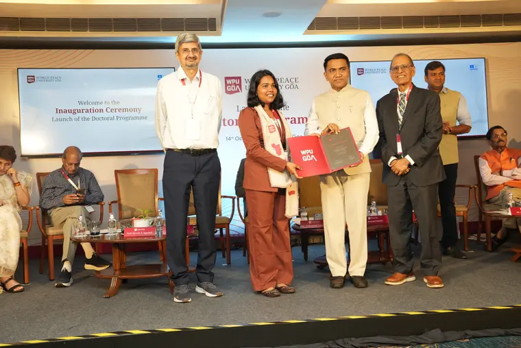A member of WPU GŌA’s first Ph.D. cohort receives her Certificate of Enrolment on stage