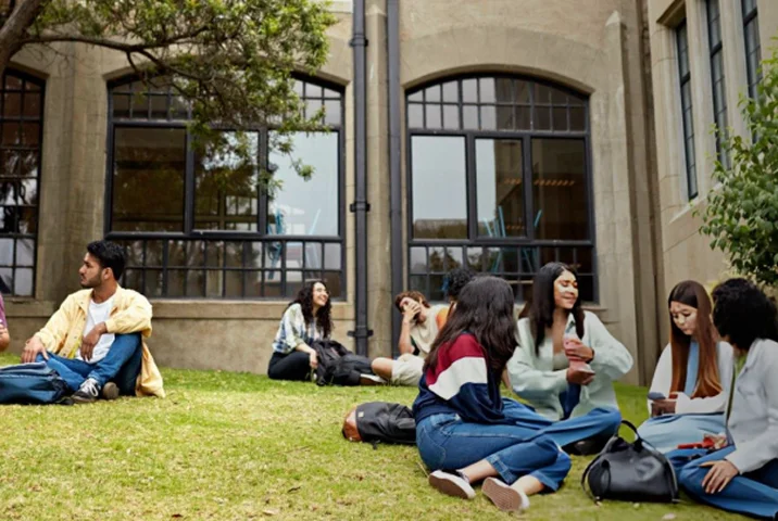 Students sitting together on the campus lawn in conversation