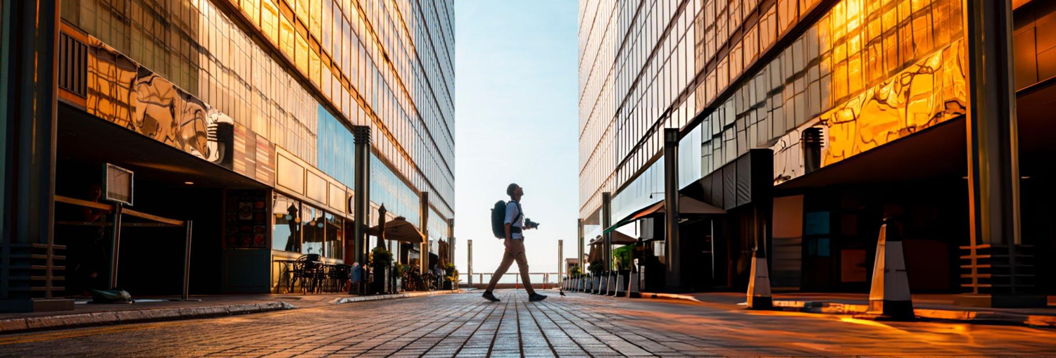 A professional walking between modern corporate buildings, capacity building for high-impact careers