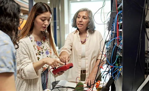 A mentor guiding students through hands-on, experiential learning