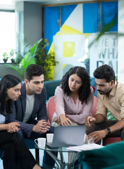 A group of students discussing and collaborating over laptops on campus