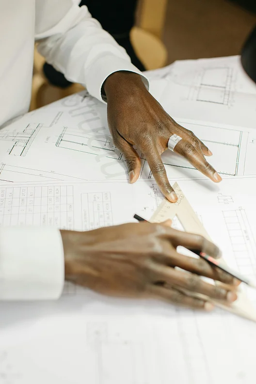 Hands working on a technical design drawing at WPU GŌA